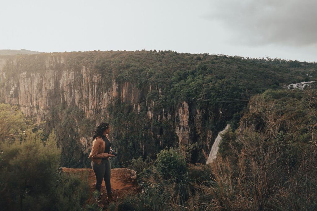 Girl holding a camera at Mtarazi falls viewpoint Zimbabwe