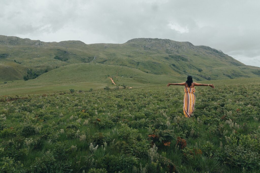 Young woman looking at the mountain, wearing a colourful dress